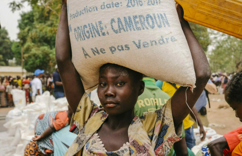 A woman holding a bag of food assistance.