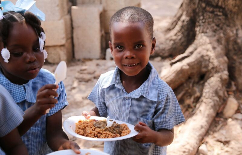 petit enfant portant une assiette de nourriture