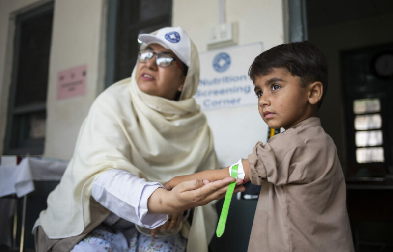 Shazia Noreen, aide-soignante, effectue une mesure de la circonférence du bras lors du dépistage nutritionnel d'Ajmal, 4 ans, à l'unité de santé de base d'Agra, soutenue par Médecins du Monde, le 21 juin 2023 à Agra, district de Charsadda, Khyber Pakhtunkhwa, Pakistan.