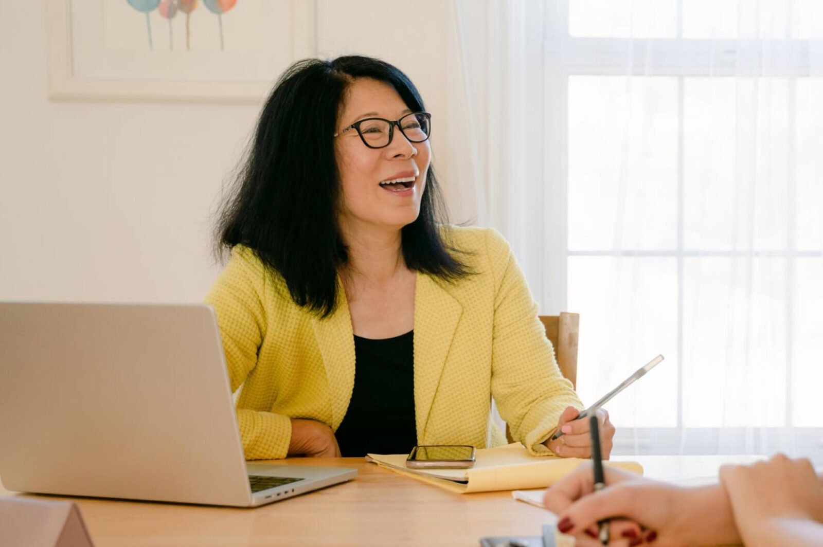 A financial advisor at her deck talking with a client, out of shot.